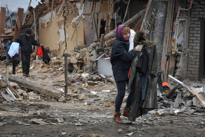 Local residents carry their belongings as they leave their home ruined in the Saturday Russian rocket attack in Zaporizhzhya, Ukraine on Sunday.