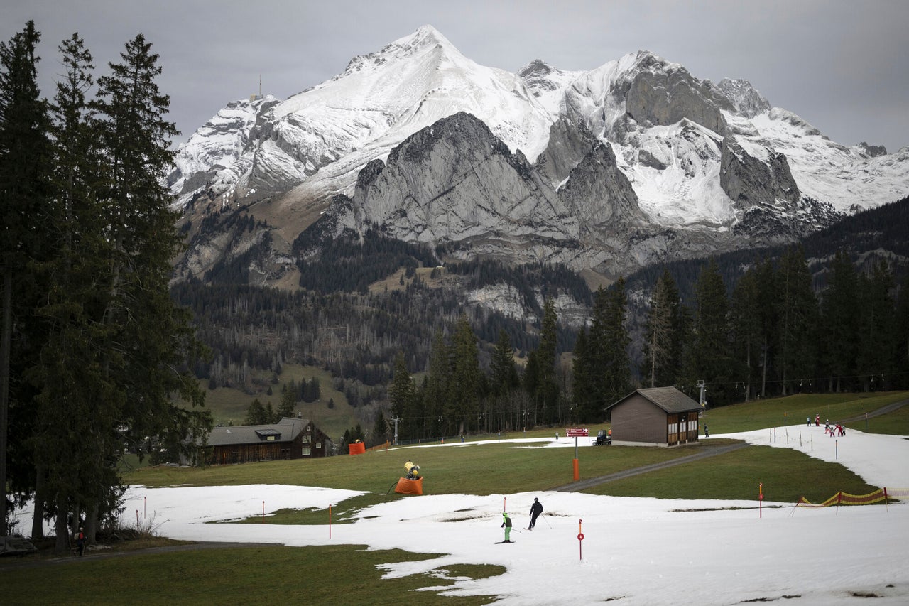 People skiing on a slope of artificial snow in Wildhaus, Switzerland, Wednesday, Jan. 4, 2023. The Swiss alps are confronted with a lack of snow and warm temperatures. (Gian Ehrenzeller/Keystone via AP)