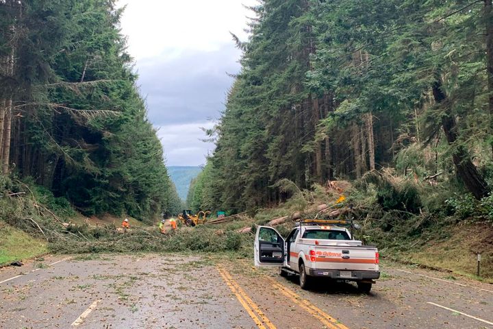 In this photo provided by Caltrans District 1, crews work at removing multiple fallen trees blocking U.S. Highway 101 in Humboldt County near Trinidad, Calif., on Jan. 4, 2023. 