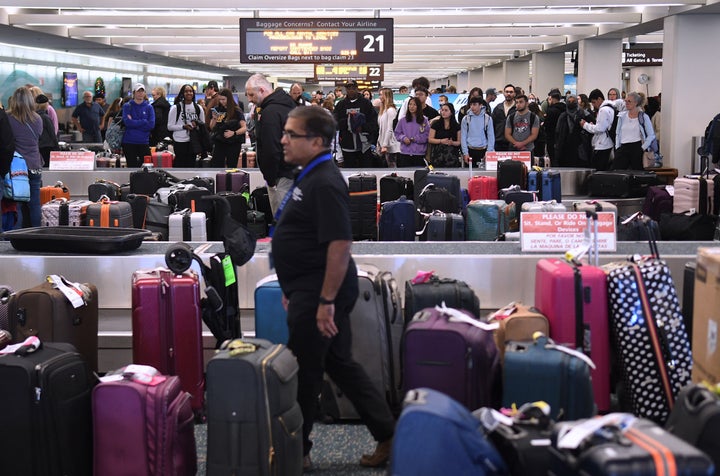 FILE – Unclaimed luggage piles up at baggage carousels at Orlando International Airport on Dec. 28, 2022.