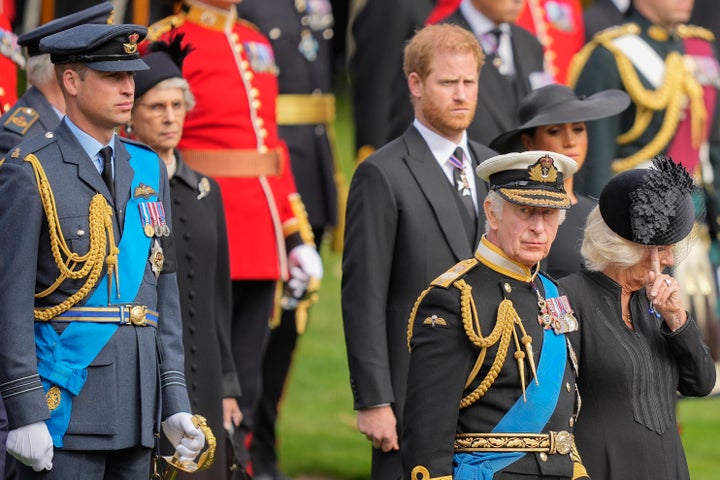 King Charles III, from right, Camilla, the Queen Consort, Meghan, Duchess of Sussex, Prince Harry and Prince William watch as the coffin of Queen Elizabeth II is placed into the hearse following the state funeral service in Westminster Abbey in central London.