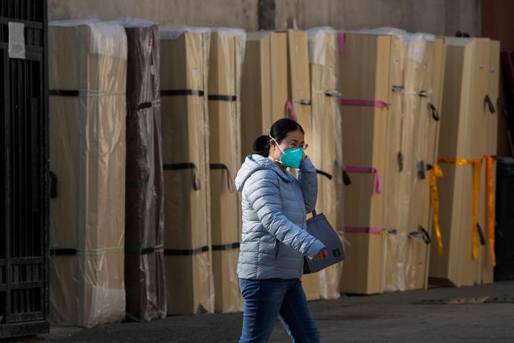 Μια γυναίκα περπατάει δίπλα σε άδεια φέρετρα που έχουν τοποθετηθεί σε νεκροτομείο σε νοσοκομείου στο Πεκίνο.