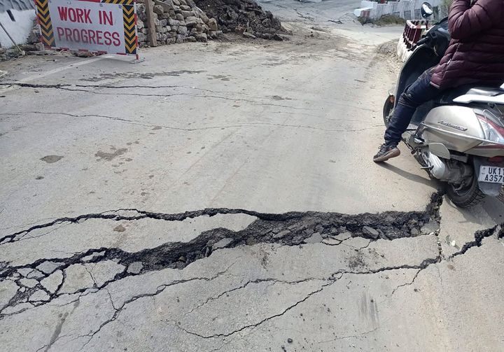 A motorist navigates his way through a crack on a road in Joshimath, India, Tuesday, Jan. 3, 2023. Authorities have stopped all construction activity and started shifting hundreds of people panicking after seeing a temple collapse and cracks in over 600 houses due to subsidence of land in a northern Indian hilly town, officials said on Saturday. (AP Photo)