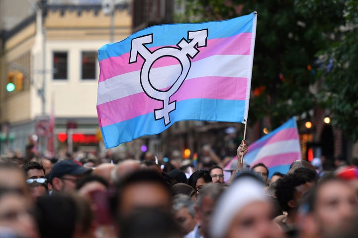 A person holds a transgender pride flag as people gather on Christopher Street outside the Stonewall Inn for a rally to mark the 50th anniversary of the Stonewall Riots in New York, June 28, 2019. - The June 1969 riots, sparked by repeated police raids on the Stonewall Inn -- a well-known gay bar in New York's Greenwich Village -- proved to be a turning point in the LGBTQ community's struggle for civil rights. (Photo by ANGELA WEISS / AFP) (Photo credit should read ANGELA WEISS/AFP via Getty Images)