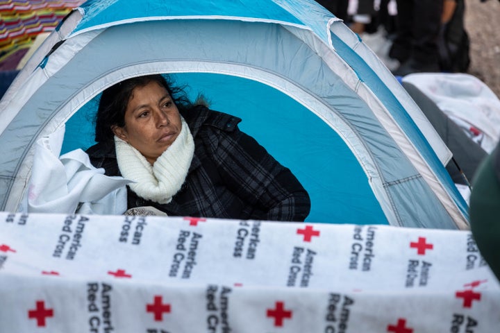 An immigrant wakes up after sleeping outside a migrant shelter on Sunday in El Paso. U.S. Border authorities took into custody more than 2.5 million migrants in 2022, the highest number on record.