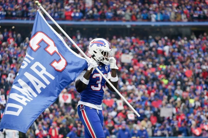 Buffalo Bills cornerback Siran Neal (33) holds a flag in support of teammate Damar Hamlin before a game against the New England Patriots on Sunday in Orchard Park, New York.