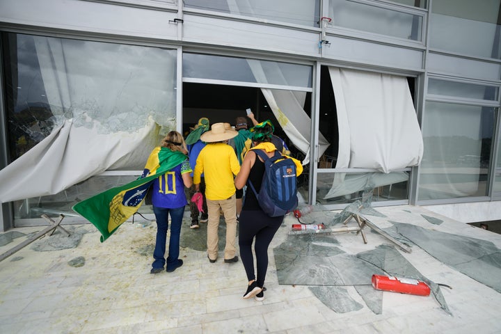 Protesters, supporters of Brazil's former President Jair Bolsonaro, storm the Planalto Palace in Brasilia, Brazil, Sunday, Jan. 8, 2023. Planalto is the official workplace of the president of Brazil. (AP Photo/Eraldo Peres)