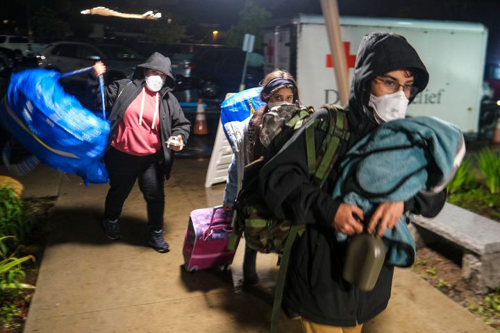 People carrying their belongs arrive at an evacuation center in Santa Barbara, Calif., on Jan. 9, 2023. 