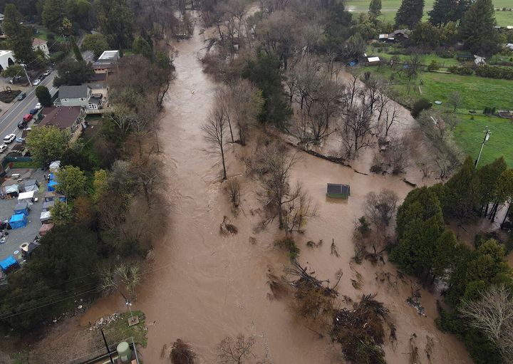 Storm-swollen San Lorenzo River flooding makes landfall along the Ocean Street Extension in Santa Cruz, California on January 9, 2023. 