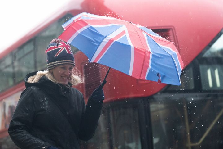 A woman walks near Westminster Bridge, central London in the rain.