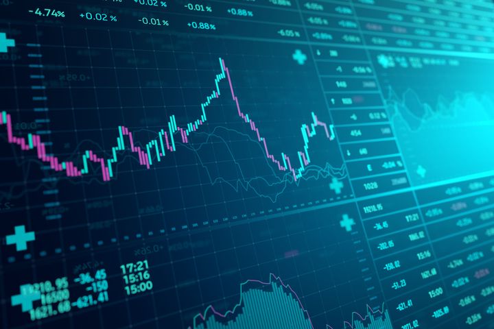 Stock market trading board on a dark green background.