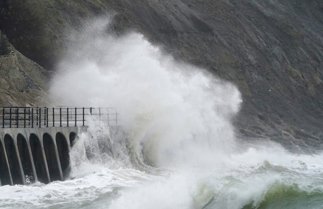 Waves crash over the promenade during rain and strong winds in Folkestone, Kent.