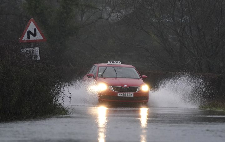 A car makes it's way through flood water on Kent Lane, near to Ibsley in Hampshire.