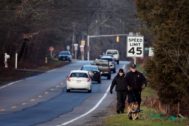 Members of a State Police K-9 unit search a road near the Walshe's home in Cohasset, Mass., on Tuesday. 