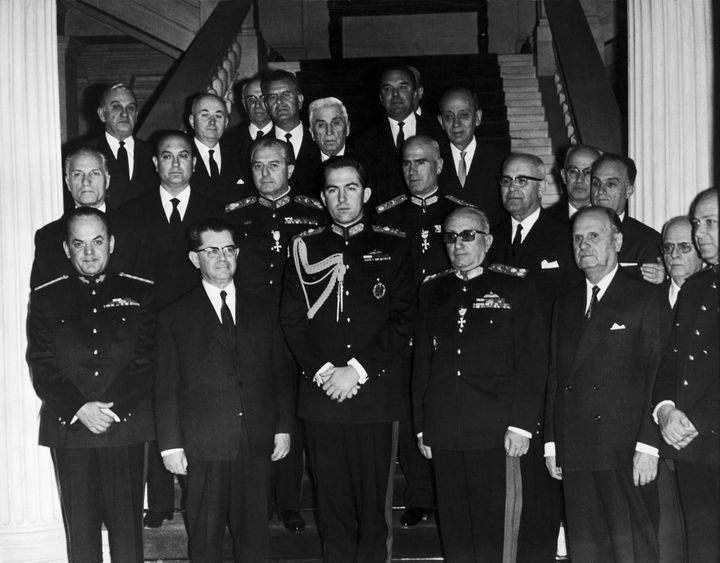 Ο βασιλιάς Κωνσταντίνος Β΄ ανάμεσα σε μέλη της δικτατορικής κυβέρνησης αμέσως μετά την ορκωμοσία του δεύτερου κλιμακίου στις 22 Απριλίου 1967. Διακρίνονται οι Παπαδόπουλος, Κόλλιας, Σπαντιδάκης, Μακαρέζος (πρώτη σειρά), Ζωιτάκης, Παττακός (δεύτερη σειρά).