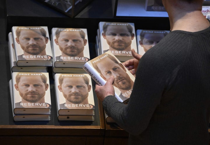 A bookseller prepares a display for the German translation of "Spare" titled "Reserve" in German.