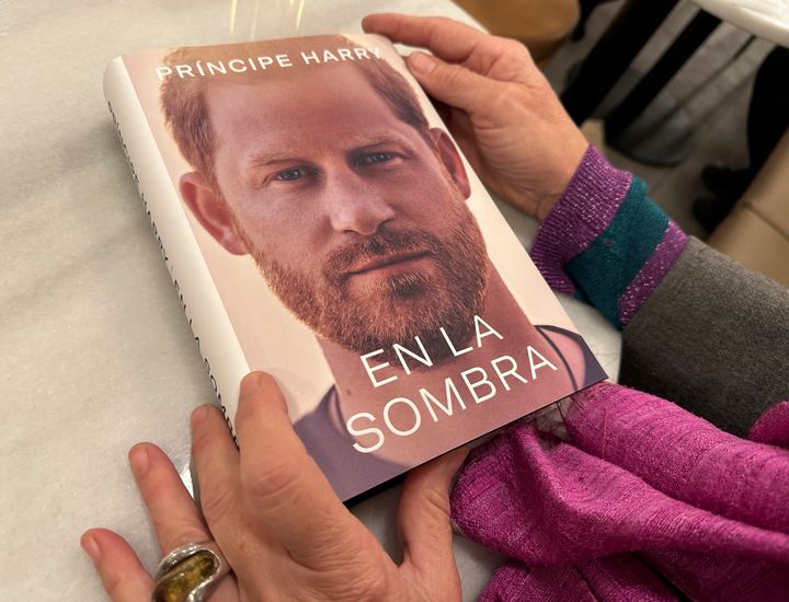 A woman holds a copy of "En La Sombra" (In the Shadow), the Spanish translation of Prince Harry's memoir, in Barcelona, Spain.