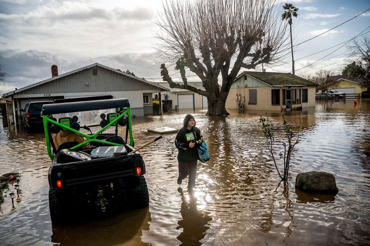Brenda Ortega, 15, salvages items from her flooded Merced, Calif., home on Tuesday, Jan. 10, 2023. (AP Photo/Noah Berger)