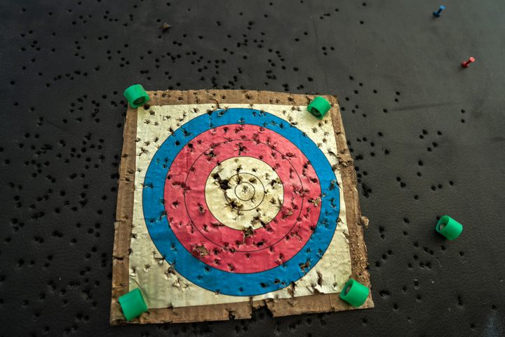 The target for practicing archery outdoors with bullet holes in the shooting .