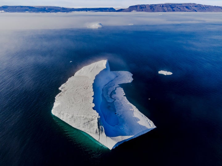 A melting pond is seen inside an iceberg from the Greenland ice sheet in the Baffin Bay near Pituffik, Greenland, on July 17, 2022.