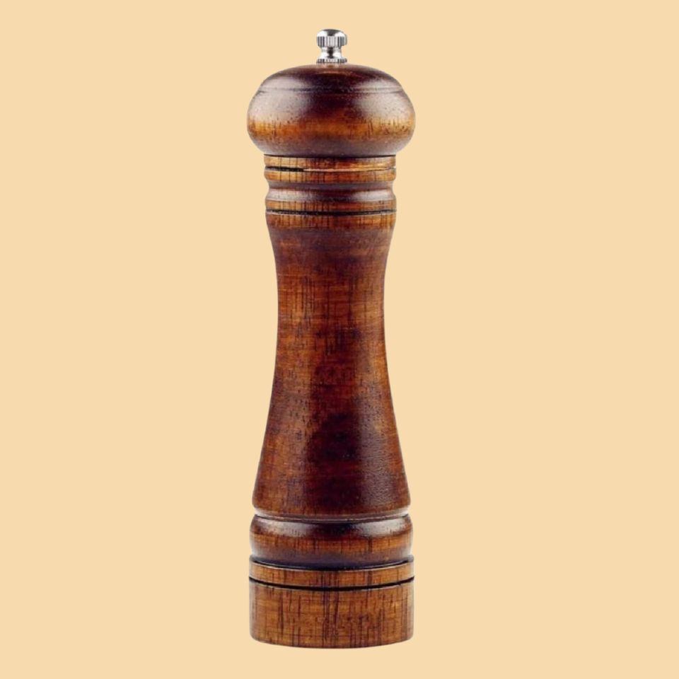 Classic wooden black pepper grinder used by a chef to season