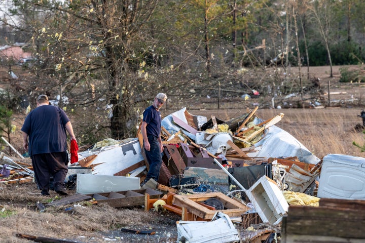 Scott Wayman, center, examines his former rental home at 1349 County Road 43 in the aftermath from severe weather, Thursday, Jan. 12, 2023, in Prattville, Ala. A giant, swirling storm system billowing across the South spurred a tornado on Thursday that shredded the walls of homes, toppled roofs and uprooted trees in Selma, Alabama, a city etched in the history of the civil rights movement.(AP Photo/Vasha Hunt)