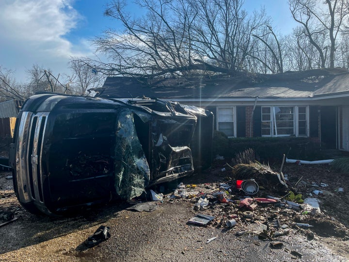 A damaged vehicle rests on its side in front of a home, on Jan. 12, 2023, in Selma, Ala. A large tornado damaged homes and uprooted trees in Alabama on Thursday as a powerful storm system pushed through the South.