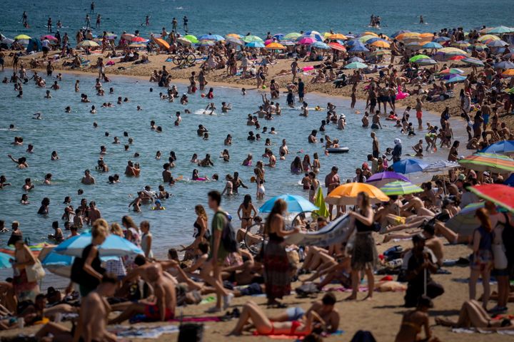 People cool off in the water on a hot and sunny day at the beach in Barcelona, Spain, July 15, 2022. Earth’s fever persisted last year, not quite spiking to a record high but still in the top five or six warmest on record, government agencies reported on Jan. 12, 2023. 