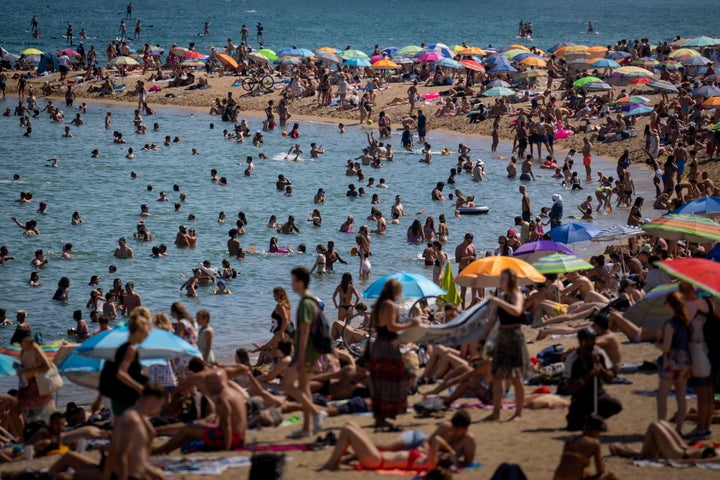 People cool off in the water on a hot and sunny day at the beach in Barcelona, Spain, July 15, 2022. Earth’s fever persisted last year, not quite spiking to a record high but still in the top five or six warmest on record, government agencies reported on Jan. 12, 2023. 