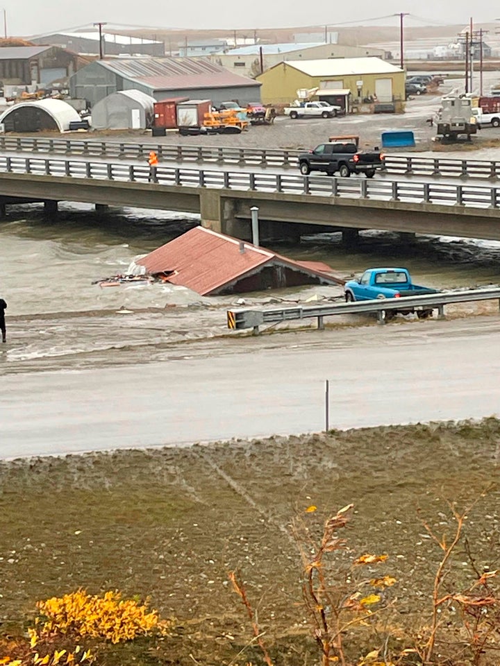 A home that was knocked off its foundation floats down Snake River during a severe storm in Nome, Alaska, is caught under a bridge on, Sept. 17, 2022. After the remnants of a rare typhoon caused extensive damage along Alaska's western coast last fall, the U.S. government stepped in to help residents, largely Alaska Natives, recovery financially.