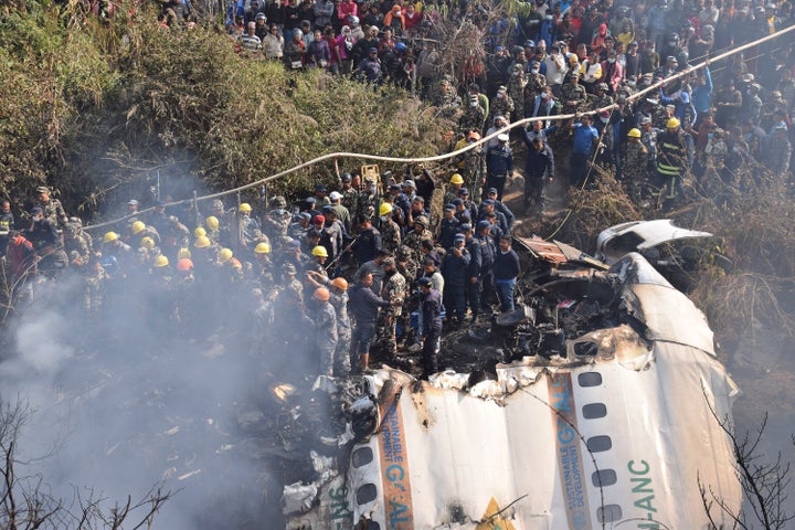 Nepalese rescue workers and civilians gather around the wreckage of a passenger plane that crashed in Pokhara, Nepal, Sunday, Jan. 15, 2023. Authorities in Nepal said 68 people have been confirmed dead after a regional passenger plane with 72 aboard crashed into a gorge while landing at a newly opened airport in the resort town of Pokhara. It's the country's deadliest airplane accident in three decades. (AP Photo/Krishna Mani Baral)