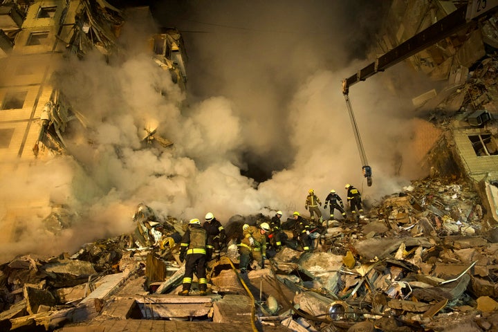 Emergency workers clear the rubble after a Russian rocket hit a multistory building leaving many people under debris in the southeastern city of Dnipro, Ukraine, Saturday, Jan. 14, 2023. (AP Photo/Evgeniy Maloletka)