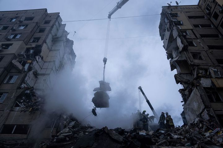 Rescue workers clear the rubble from an apartment building that was destroyed in a Russian rocket attack at a residential neighbourhood in the southeastern city of Dnipro, Ukraine, Sunday, Jan. 15, 2023. (AP Photo/Evgeniy Maloletka)