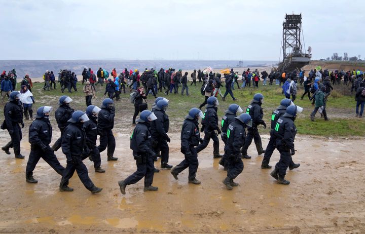 Police officers walk next to protestors at the Garzweiler mine.