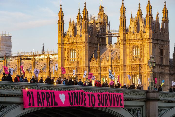 Climate activists from Extinction Rebellion drop a huge banner reading 'April 21st Unite To Survive' from Westminster Bridge on 11 January 2023.