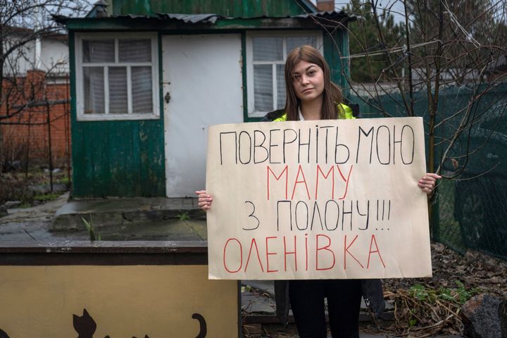 Alina Kapatsyna holds a poster that reads: "Bring back my mom from captivity," written in Ukrainian, in Dnipro, Ukraine.