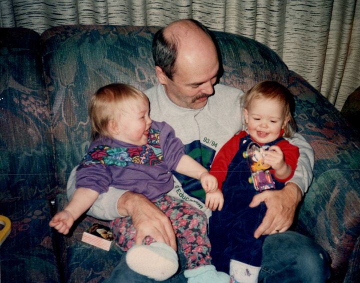 The author (right) and her sister Madeline (left) being held by their dad.