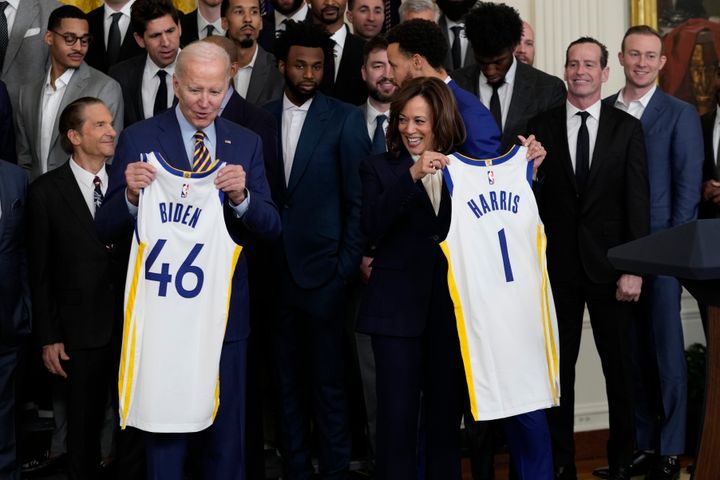 President Joe Biden and Vice President Kamala Harris hold up team jerseys as they welcome the 2022 NBA champions, the Golden State Warriors, to the East Room of the White House.