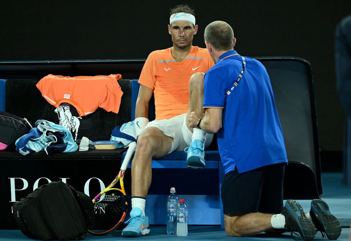 Spain's Rafael Nadal gets medical attention between the break in the men's singles match against Mackenzie McDonald of the US on day three of the Australian Open tennis tournament in Melbourne on January 18, 2023. - -- IMAGE RESTRICTED TO EDITORIAL USE - STRICTLY NO COMMERCIAL USE -- (Photo by MANAN VATSYAYANA / AFP) / -- IMAGE RESTRICTED TO EDITORIAL USE - STRICTLY NO COMMERCIAL USE -- (Photo by MANAN VATSYAYANA/AFP via Getty Images)
