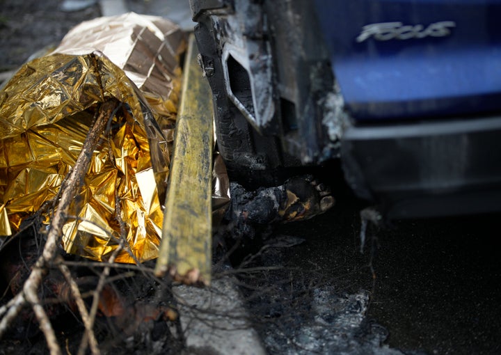 A dead body on the ground at the scene where a helicopter crashed on civil infrastructure in Brovary, on the outskirts of Kyiv, Ukraine, on Jan. 18, 2023. 