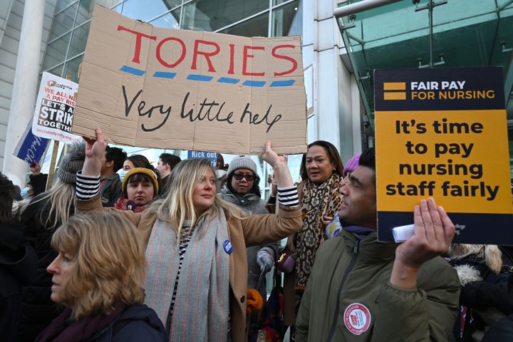 Nursing staff and supporters chant and wave placards as they protest outside University College Hospital during a day of strikes, on January 18, 2023