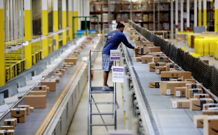 An Amazon employee makes sure a box riding on a belt is not sticking out at the Amazon Fulfillment center in Robbinsville Township, N.J. OSHA announced several workplace safety fined against Amazon on Wednesday.