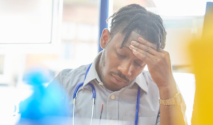 Junior doctor at his desk in his office performing various tasks