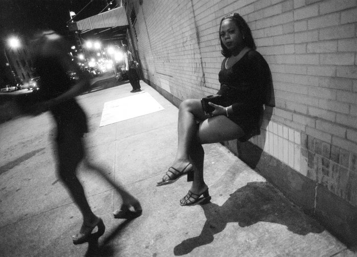 Two transgender sex workers stop to relax momentarily while strolling through the meatpacking district in New York City in June 1999.