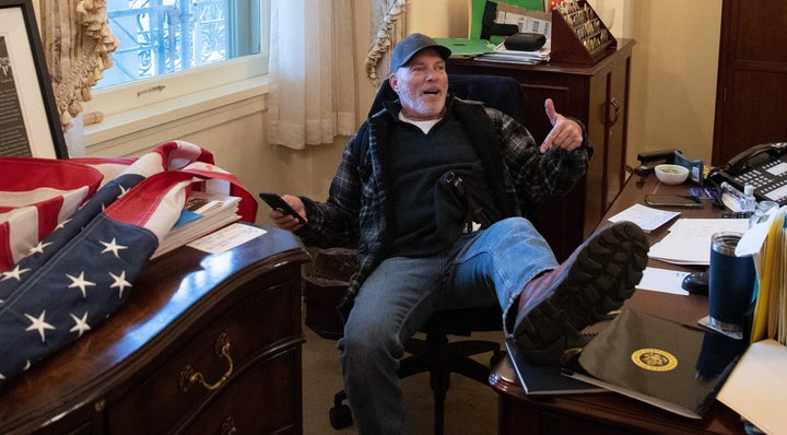 Richard Barnett sits inside the office of Speaker of the House Nancy Pelosi on Jan. 6, 2021.