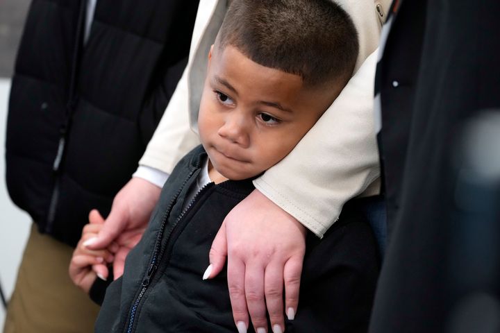 Syncere Kai Anderson, 5, is held by his mother, Gabrielle Hansell, as he listens laywers Benjamin Crump, and Carl Douglas, hold a news conference to announce filing a $50 million in damages claim against the city of Los Angeles over the death of his father, Keenan Anderson in Los Angeles Friday, Jan. 20, 2023.