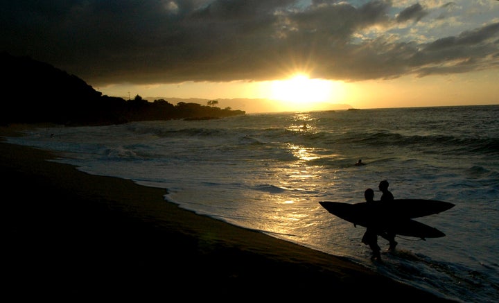 Eddie participants walk out of the ocean at sunset after the November 2006 opening ceremony in Waimea Bay near Haleiwa, Hawaii.