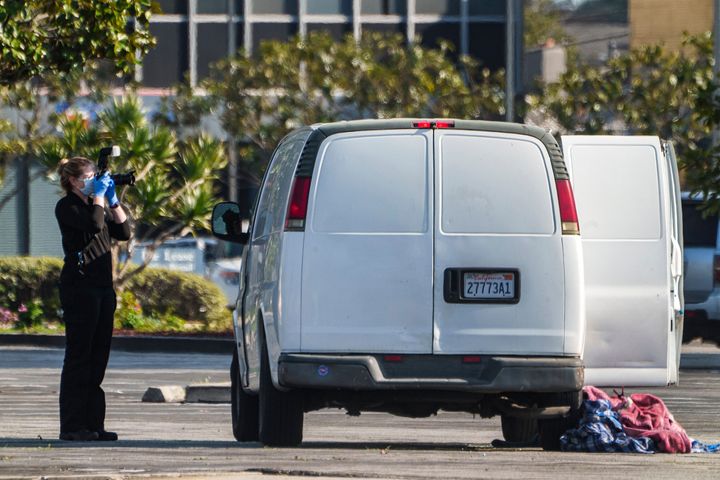 A forensic photographer takes pictures of a van's window and its contents in Torrance, Calif., on Jan. 22, 2023. A mass shooting took place at a dance club following a Lunar New Year celebration, setting off a manhunt for the suspect. 