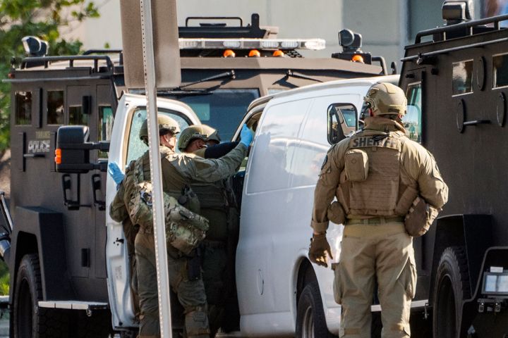 Members of a SWAT team enter a van and look through its contents in Torrance Calif., on Jan. 22, 2023.