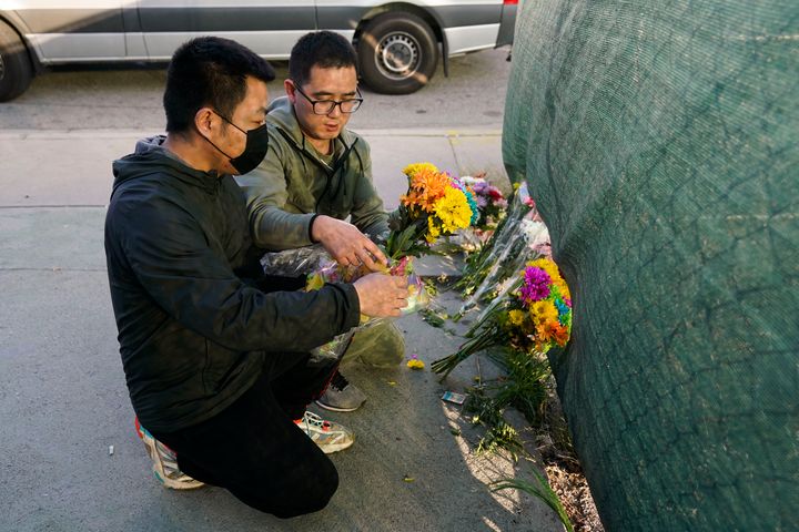 Two men place flowers near Star Dance Studio to honor victims killed in a shooting in Monterey Park, Calif., on Jan. 22, 2023. 